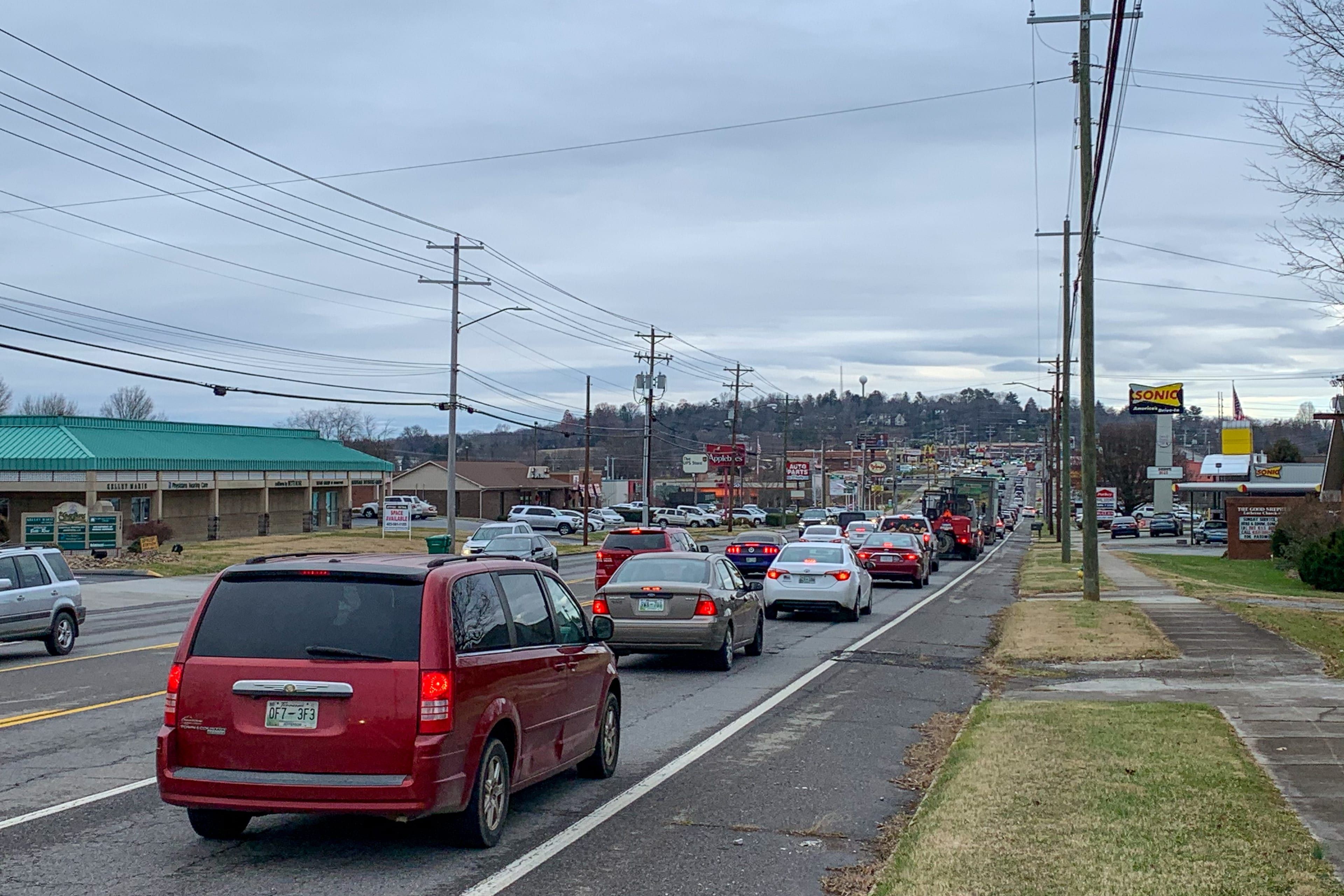 Cars backed up on a four-lane commercial road lined with shops and power lines in Tennessee